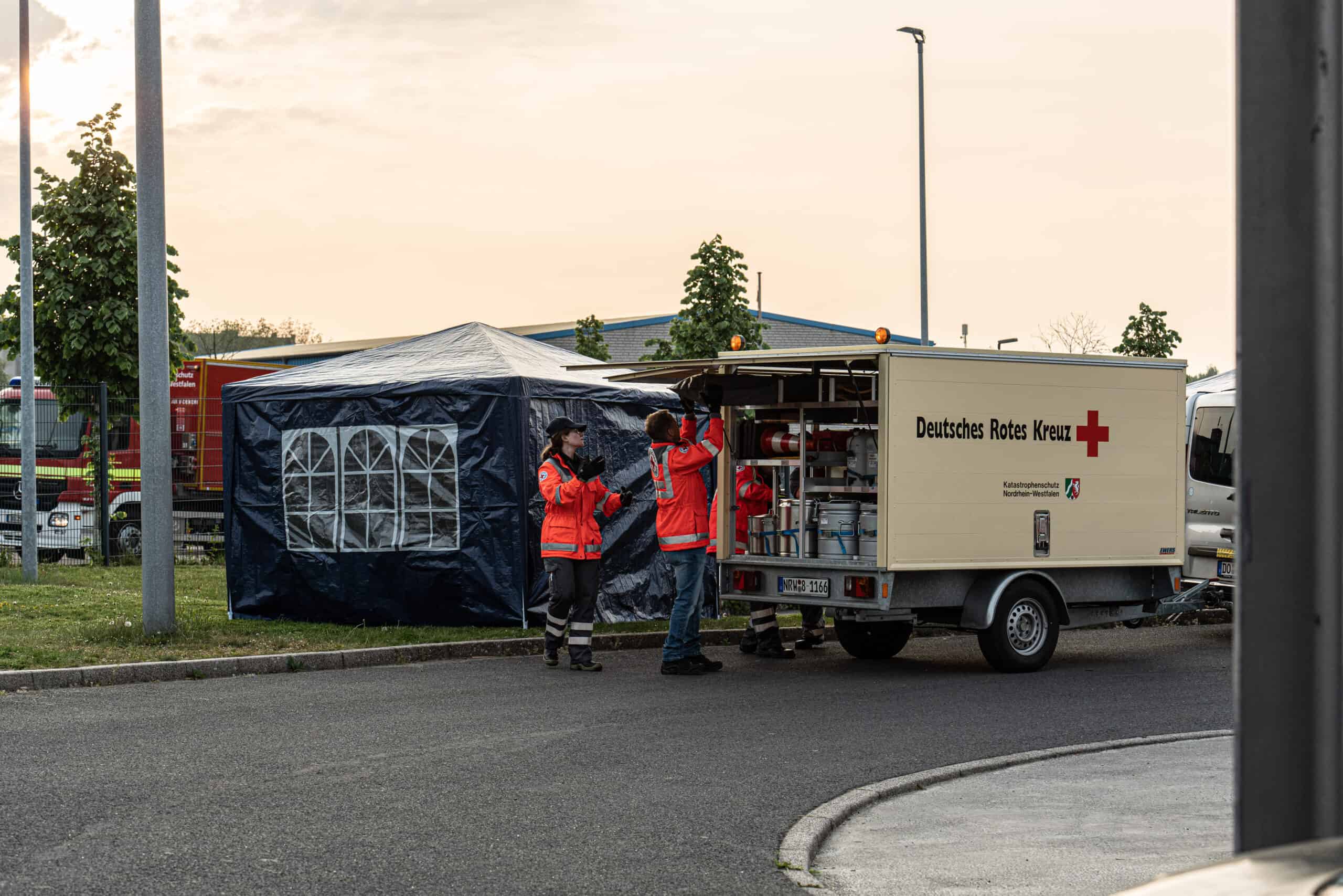 Two staff of German Red Cross Dortmund are unloading equipment from the van